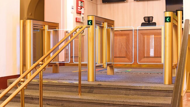 Praha, Pražská konzervatoř – turnikety ve zlaté barvě ladí se zlatým zábradlím schodiště, na které navazují | © Archiv COMINFO a.s.