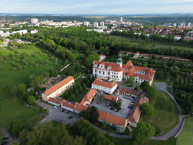 Areál Břevnovského kláštera, atypický pohled z ptačí perspektivy, na pozadí sídliště Petřiny a Červený Vrch. Zkoumaná plocha válečných hrobů leží vlevo za budovou sýpky. | © Egon Ditmar