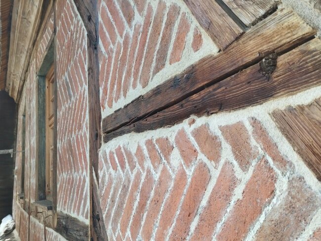 Detail hrázděné části fasády s klasovým zdivem | © Jakub Ivánek