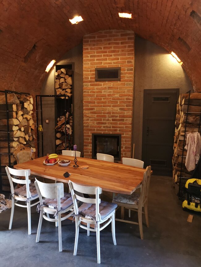 Zrenovovaná obytná část objektu s jídelním koutem a krbem | © Petr Semrád