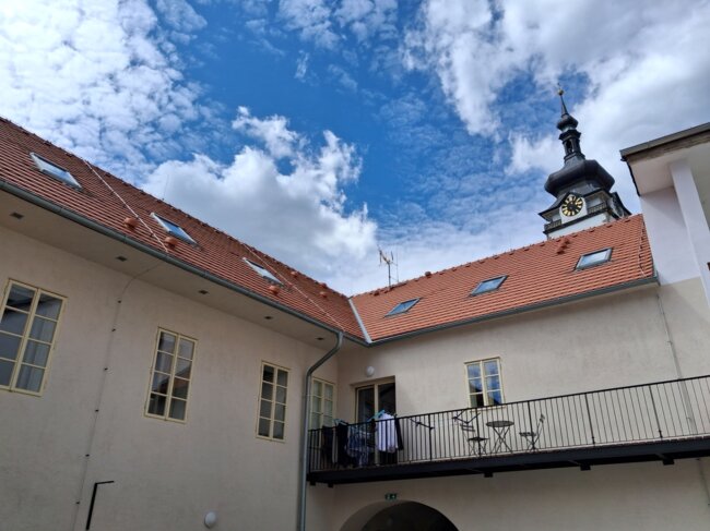 Pohled ze dvora domu na nové střechy, v pozadí věž děkanského kostela. | © Zbyněk Konvička