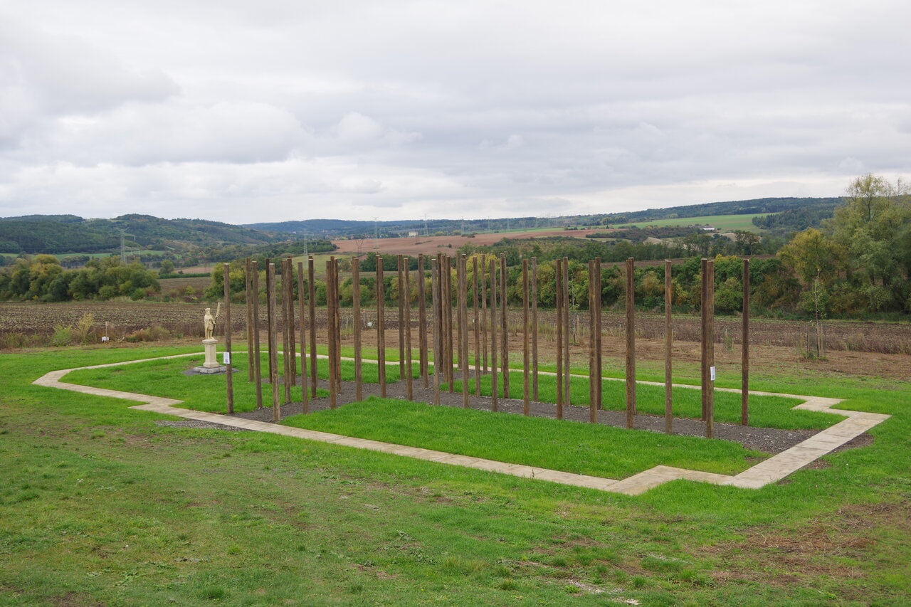 Betonovými dlaždicemi obnovený půdorys zaniklého svatostánku, který je ve vnitřní ploše doplněný o půdorysný kříž vytvořený z chmelových sloupů a kamennou sochou sv. Václava. | © Laurencia Helásková