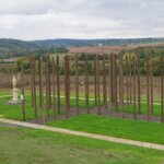 Betonovými dlaždicemi obnovený půdorys zaniklého svatostánku, který je ve vnitřní ploše doplněný o půdorysný kříž vytvořený z chmelových sloupů a kamennou sochou sv. Václava. | © Laurencia Helásková