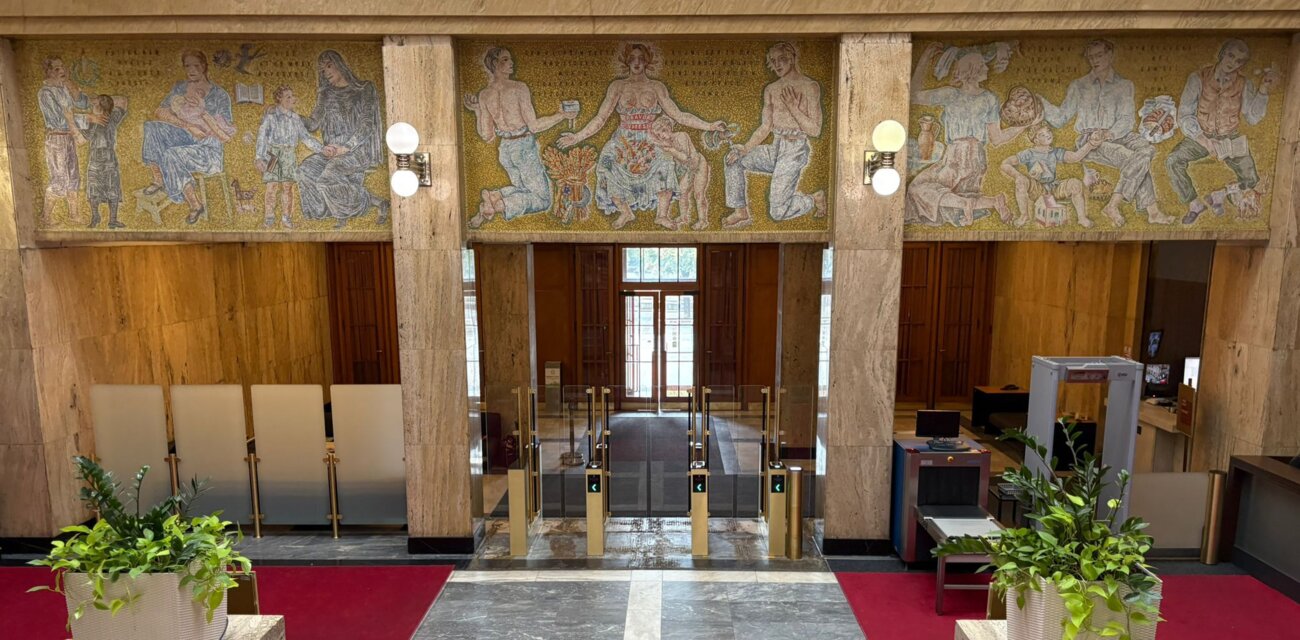 Praha-Nové Město, Ministerstvo zdravotnictví ČR – zlaté kontrolní turnikety a boční zábrany z mléčného skla v kontrastu s mozaikou od Františka Kysely | © Archiv COMINFO a. s.