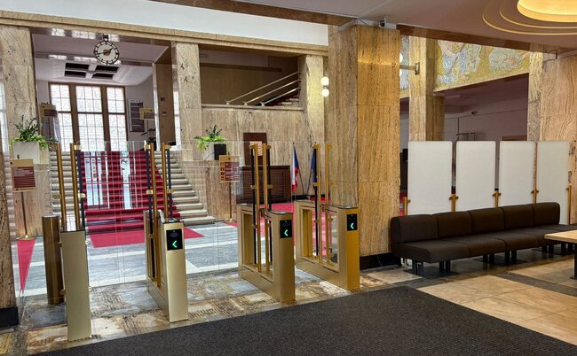 Praha-Nové Město, Ministerstvo zdravotnictví ČR – zlaté kontrolní turnikety a boční zábrany z mléčného skla před vstupem do schodišťové haly | © Archiv COMINFO a. s.