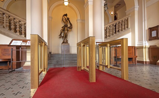 Zlaté provedení vstupních turniketů, byť s jiným tvaroslovím, bylo v minulosti realizováno také v historičtějším prostředí, konkrétně pak u schodiště služebního vchodu do Národního divadla v Praze.  | © Archiv COMINFO a. s.