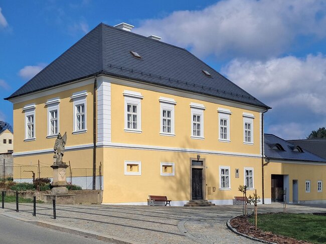 Plocha čelní fasády a bočních fasád je natřena žlutou barvou a šambrány, římsy a armování jsou na ní vyznačeny bílou.  | © Pavel Kotrla
