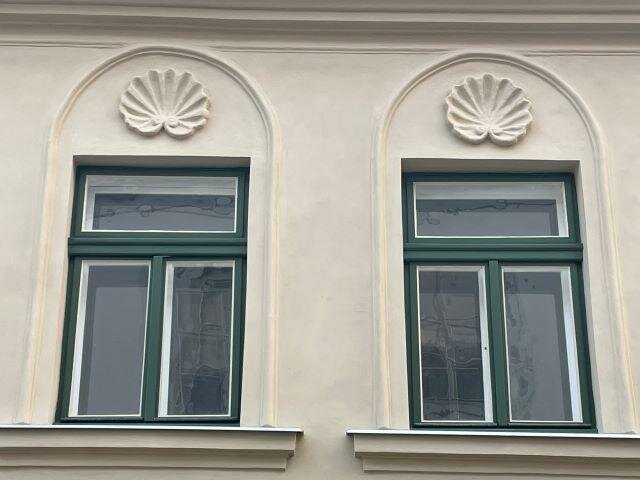 Detailní pohled na repasovaná okna a zrestaurované štukové lastury