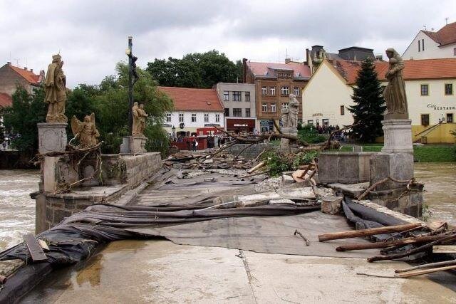 Kamenný most tísiciletou povodeň v roce 2002 ustál. Na spoušť shlíží v pozadí dům U Slona.