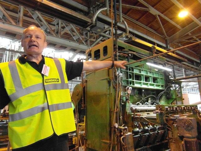 Jiří Hrdina, technolog Tondachu, hovoří o razicím lisu, kam se vkládá 24 kusů sádrových forem. Po vytlačení patřičného tvaru se přebývající části odříznou a tašky putují do sušárny.