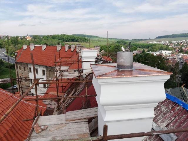 Pohled přes nově opravené komíny na zrekonstruované střechy kláštera