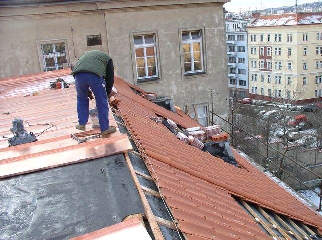 Pokrývač na hřebenu jedné ze střech kláštera
