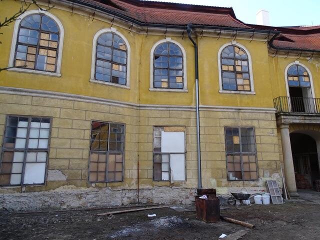 Poškozený stav vnějších omítek před obnovou
