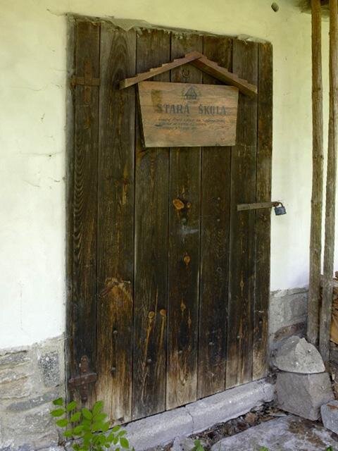 Upomínku na původní školní charakter domu tvoří dřevěná tabule se stručnou historií místa.