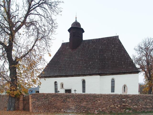 Kostel má šindelovou střechu s charakteristickou nízkou věžičkou a obdélný vstup v kamenném ostění na jižní straně.