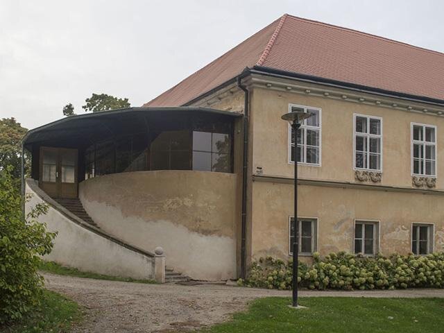 Oživující prvek představuje na jižní straně zimní zahrada půlkruhového půdorysu s kamenným schodištěm a subtilními okny.