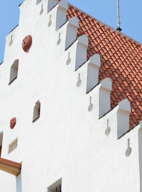 Gotický štít českobudějovické solnice s do kamene vytesanými tvářemi
