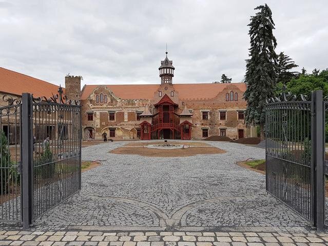 V hlavním průčelí je charakteristická předstupující mohutná konstrukce schodiště se zastřešenými rameny pultovými a jehlancovými střechami. 
