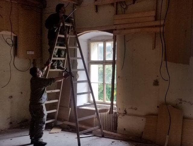 Redaktoři Milan Daněk a Zbyněk Konvička odstraňovali dřevotřískové obložení stěn.