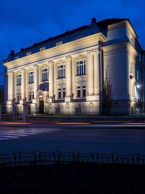 Bylo docíleno liniového nasvícení sloupů s jemným přisvícením fasády s okny a podsvícení střešní římsy bez jasových kontrastů.