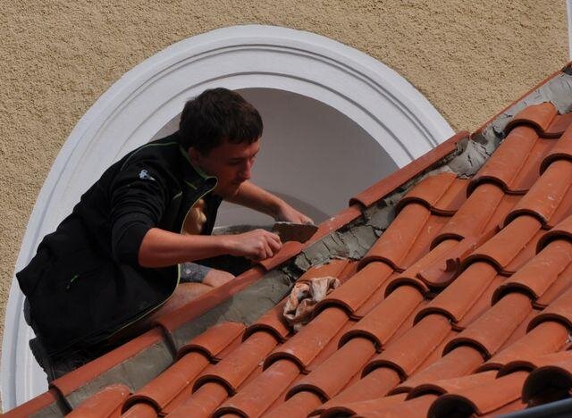 Pokrývač při práci s prejzovou krytinou pokládanou do malty