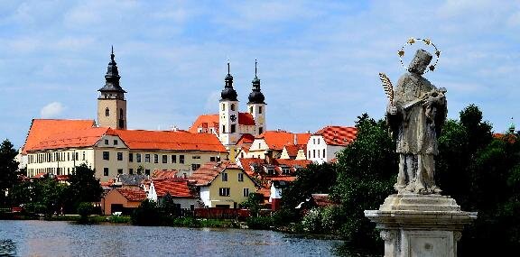 Při fotografování Telče přes Ulický rybník jsou významnými místy panoramatu města bývalá jezuitská kolej a barokní kostel Jména Ježíš.