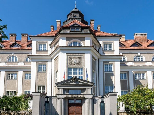 Gymnázium s obnovenými střechami nad centrální a pravou částí budovy