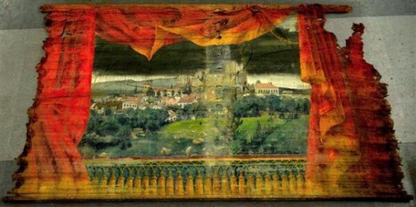 Na divadelní oponě je vyobrazeno město Lipnice nad Sázavou po požáru v roce 1869.