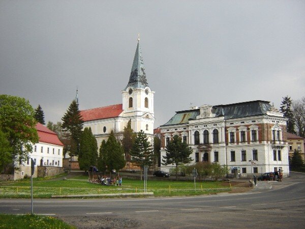 Barokní kostel sv. Jiří, vlevo od něj je fara a vpravo budova radnice.