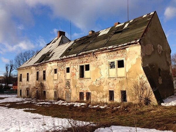 Současný zámek (na archivním snímku) mohl vzniknout přestavbou a rozšířením původního panského sídla. Dodnes obsahuje starší stavební relikty tvrze.