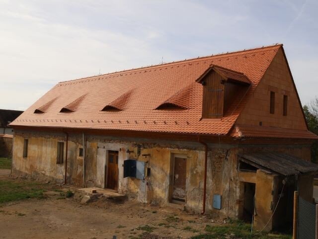 Nová střecha na poplužním dvoře s krásně vyskládanými volskými oky