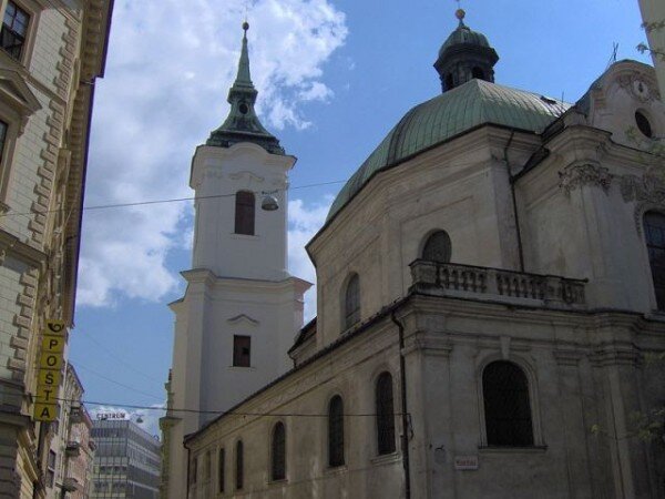 Kostel sv. Janů, v pozadí věž kostela Panny Marie Loretánské