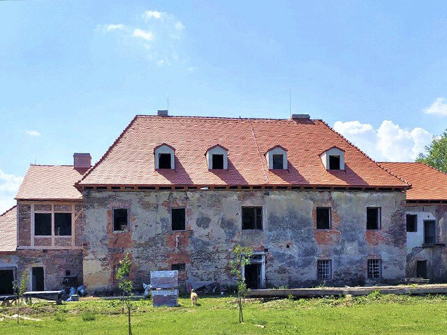 Areál dvora se zámkem a s řadou budov se rozkládá v severní části vsi.