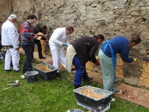Každý začátek je těžký… první pokusy o přemístění malty ze lžíce na zeď pod lektorským vedením profesora Václava Girsy.