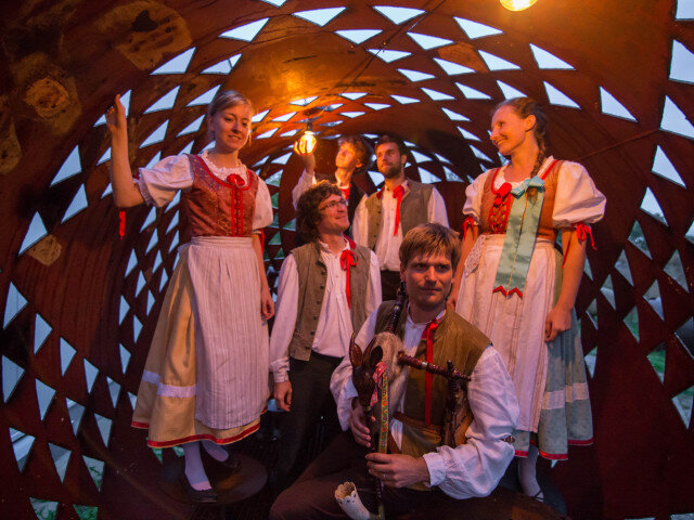 Vojtěch Kouba (v popředí) se členky Lidové muziky z Chrástu v soše Čestmíra Sušky