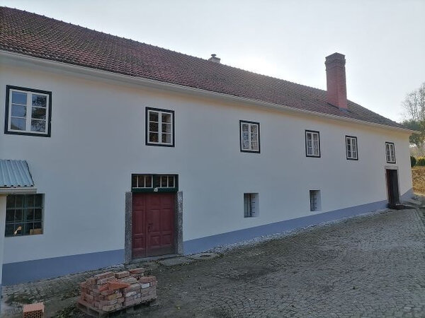 Řihákův mlýn je opět oděn do příjemné bílé fasády.