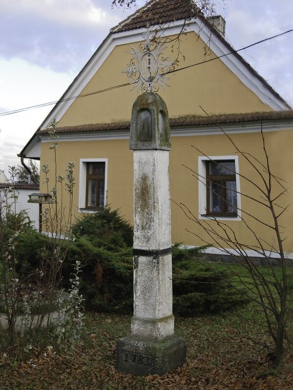 Pozdně barokní boží muka jsou uprostřed stažena kovovým páskem. 