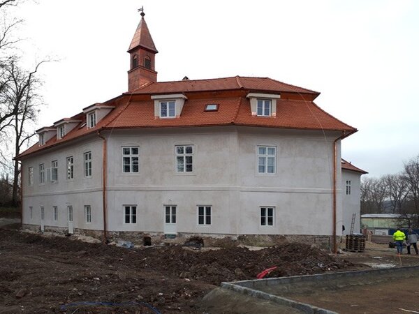 Patrový zámek má nepravidelný půdorys se čtyřmi nestejnými křídly zalomenými kolem nádvoří, na části budovy je mansardová střecha s vížkou.