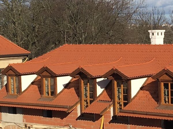 Dokončená střecha s řadou vikýřů jednoho z objektů Hájčího dvora, kde byly použity bobrovky Tondach.